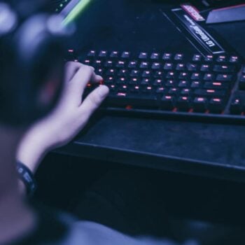 Cropped image of young gamer playing video games on computer
