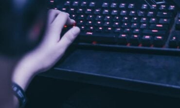 Cropped image of young gamer playing video games on computer