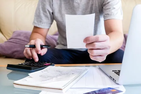 Selective,Focus,Of,Men,Using,Calculator,,Holding,Invoice,And,Check