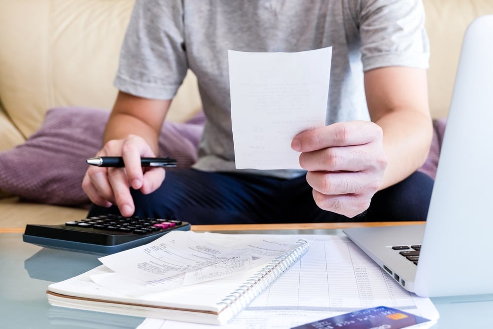 Selective,Focus,Of,Men,Using,Calculator,,Holding,Invoice,And,Check